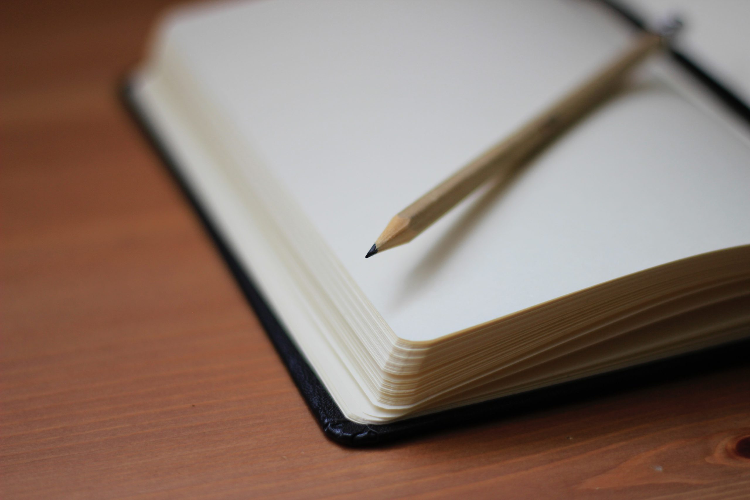 Caderno em branco e lápis numa superfície de madeira